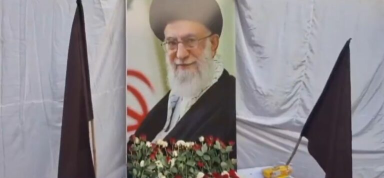 मोमिनपारा क्षेत्र में एकत्र लोग हाथों में पोस्टर लेकर विरोध प्रदर्शन करते हुए